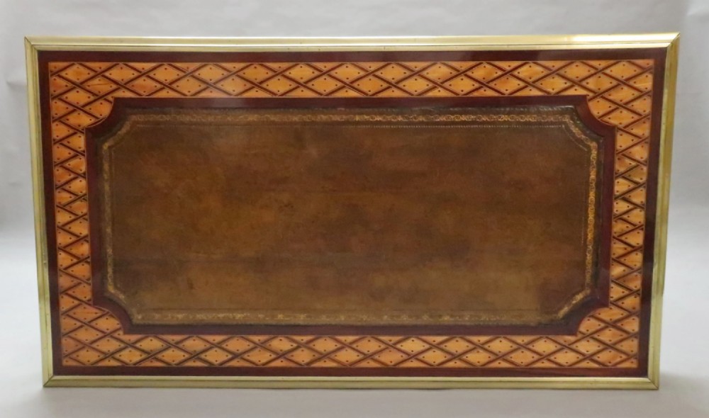 A Victorian writing table featuring geometric parquetry inlay, a brown leather inset top, gilt-brass edge moulding, two frieze drawers, and square tapered legs on castors. View III