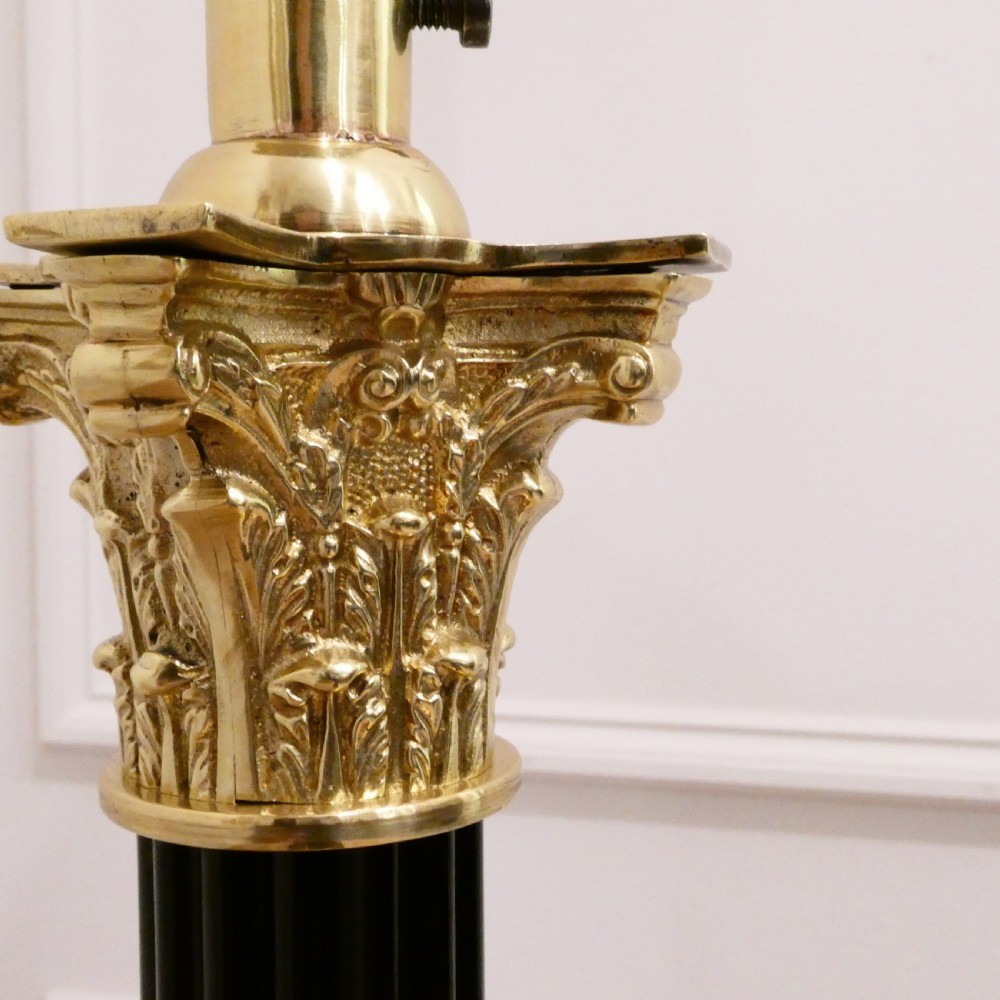 A Victorian brass standard floor lamp featuring a Corinthian capital, stepped base with claw feet, and a fringed cream shade with red tassels. View II