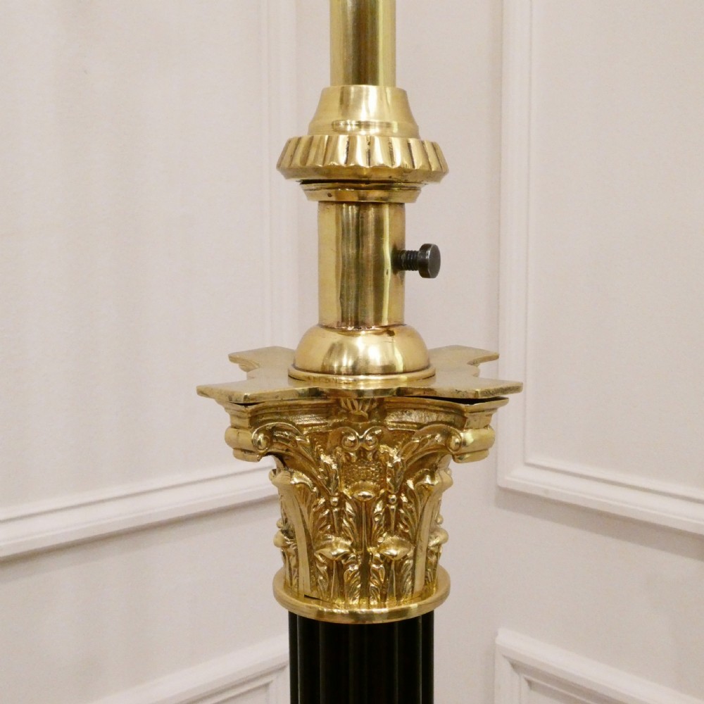 A Victorian brass standard floor lamp featuring a Corinthian capital, stepped base with claw feet, and a fringed cream shade with red tassels. View III
