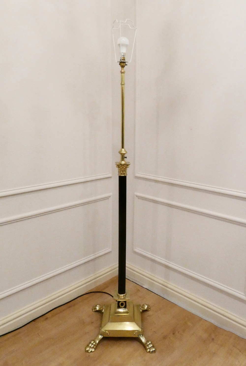 A Victorian brass standard floor lamp featuring a Corinthian capital, stepped base with claw feet, and a fringed cream shade with red tassels. View IX