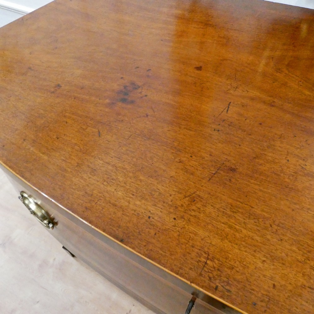A Georgian mahogany bowfront side table featuring a single drawer with two oval brass handles and square tapered legs. View VIII