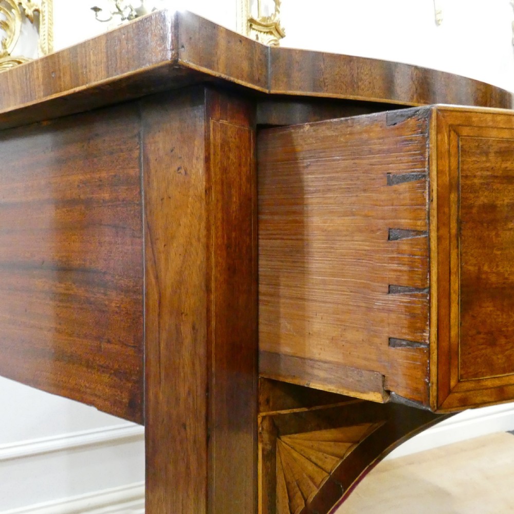 A Georgian mahogany bowfront side table featuring a single drawer with two oval brass handles and square tapered legs. View XII