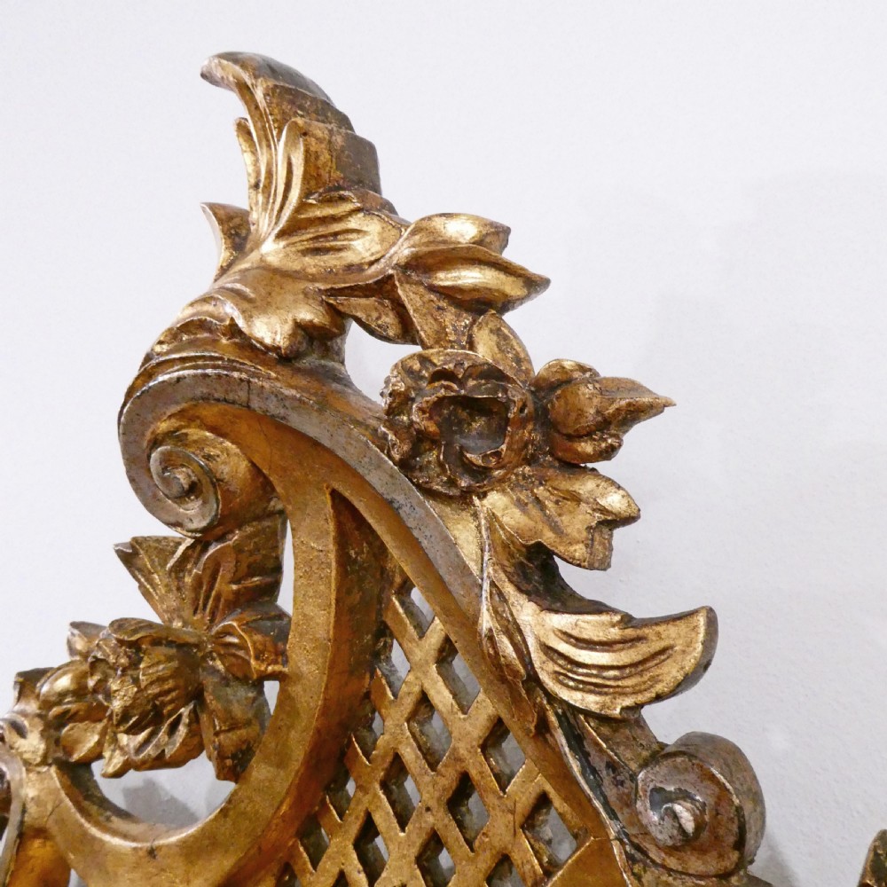 A French Rococo style wall mirror featuring a carved gold leaf frame decorated with acanthus leaf motifs, C-scrolls, and a lattice cartouche crest. View VII