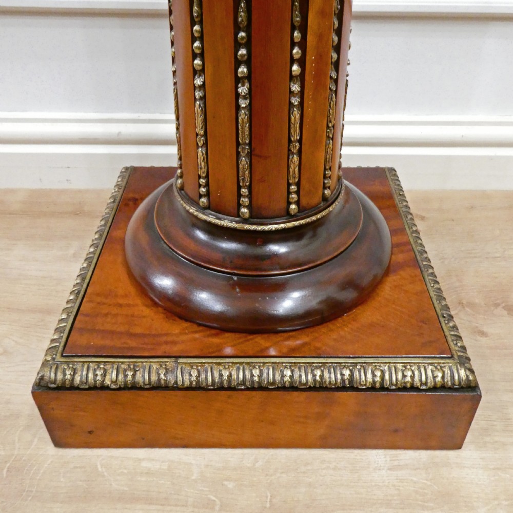 A pair of Victorian fluted satinwood column pedestals with square white marble tops and gilt mounts on plinth bases. View VII