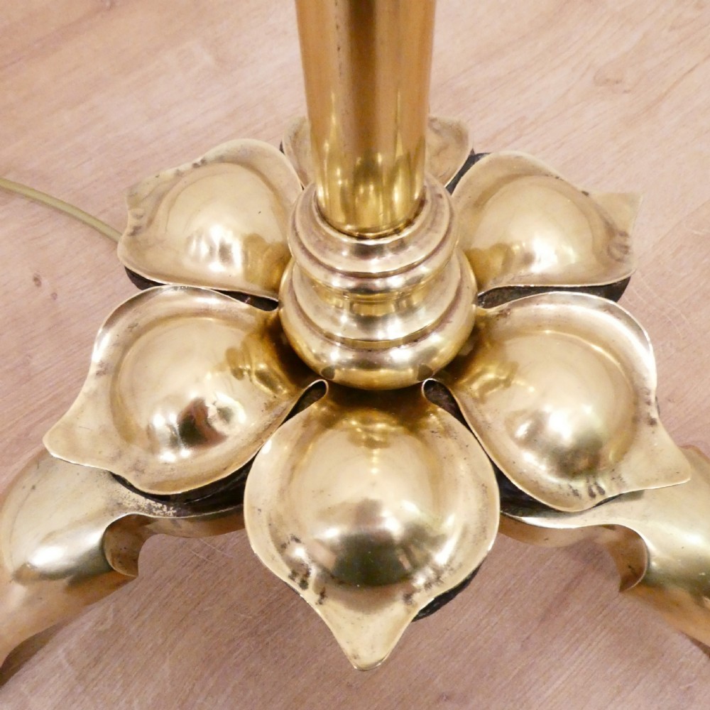 A tall brass standard lamp featuring a tripod base, slender central stem, and a gold fabric dome shade decorated with tassels and fringe. View III