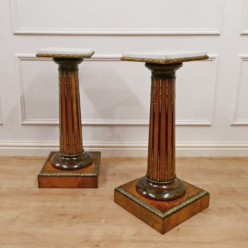 A pair of Victorian fluted satinwood column pedestals with square white marble tops and gilt mounts on plinth bases. View II