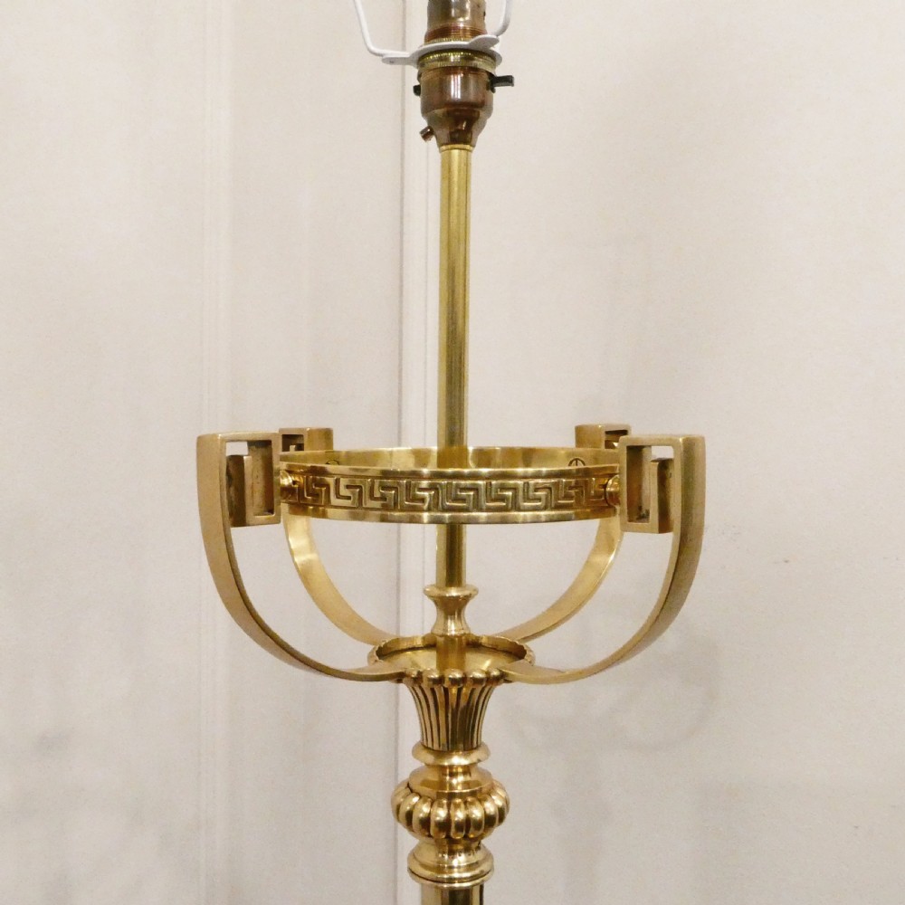 A tall Victorian brass standard lamp featuring a fluted column, tiered square base, and a domed gold silk shade trimmed with beaded fringe and red tassels. View II