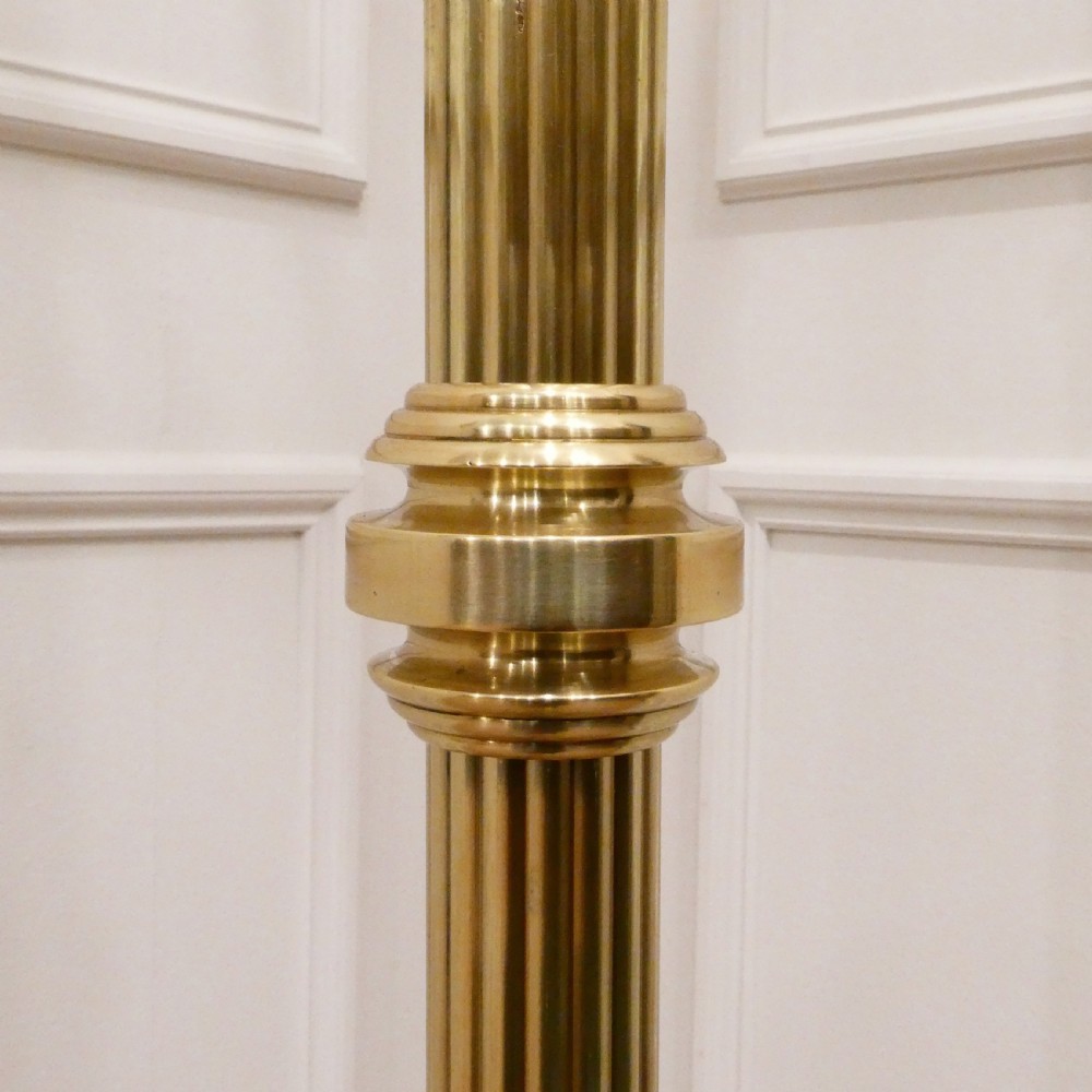 A tall Victorian brass standard lamp featuring a fluted column, tiered square base, and a domed gold silk shade trimmed with beaded fringe and red tassels. View VIII
