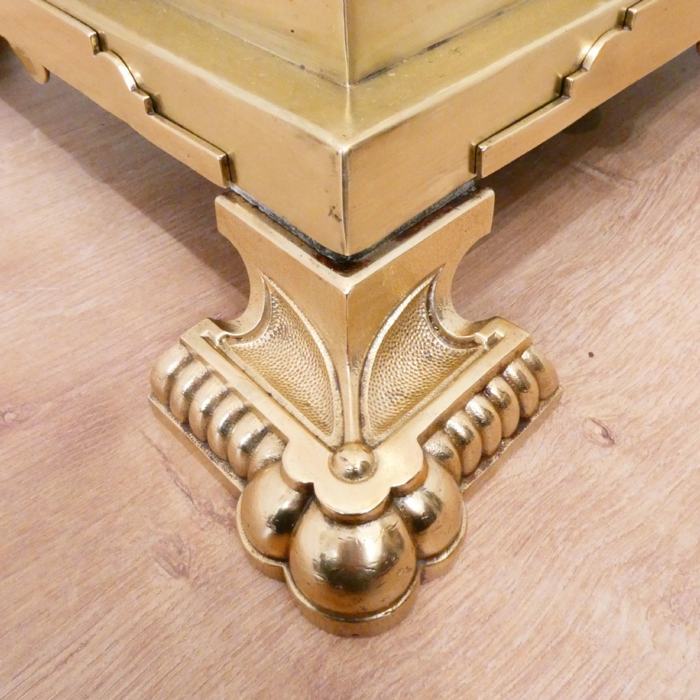 A tall Victorian brass standard lamp featuring a fluted column, tiered square base, and a domed gold silk shade trimmed with beaded fringe and red tassels. View IX