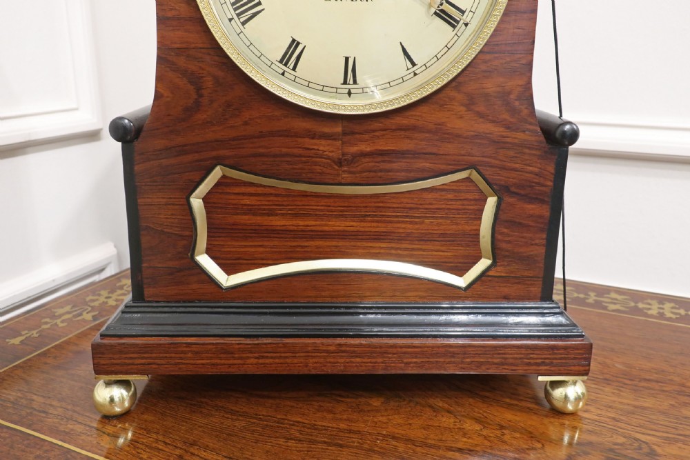 A Georgian kingwood bracket clock featuring a pointed arched case, brass ball feet, and a cream dial signed Turner Fenchurch Street London. View VI