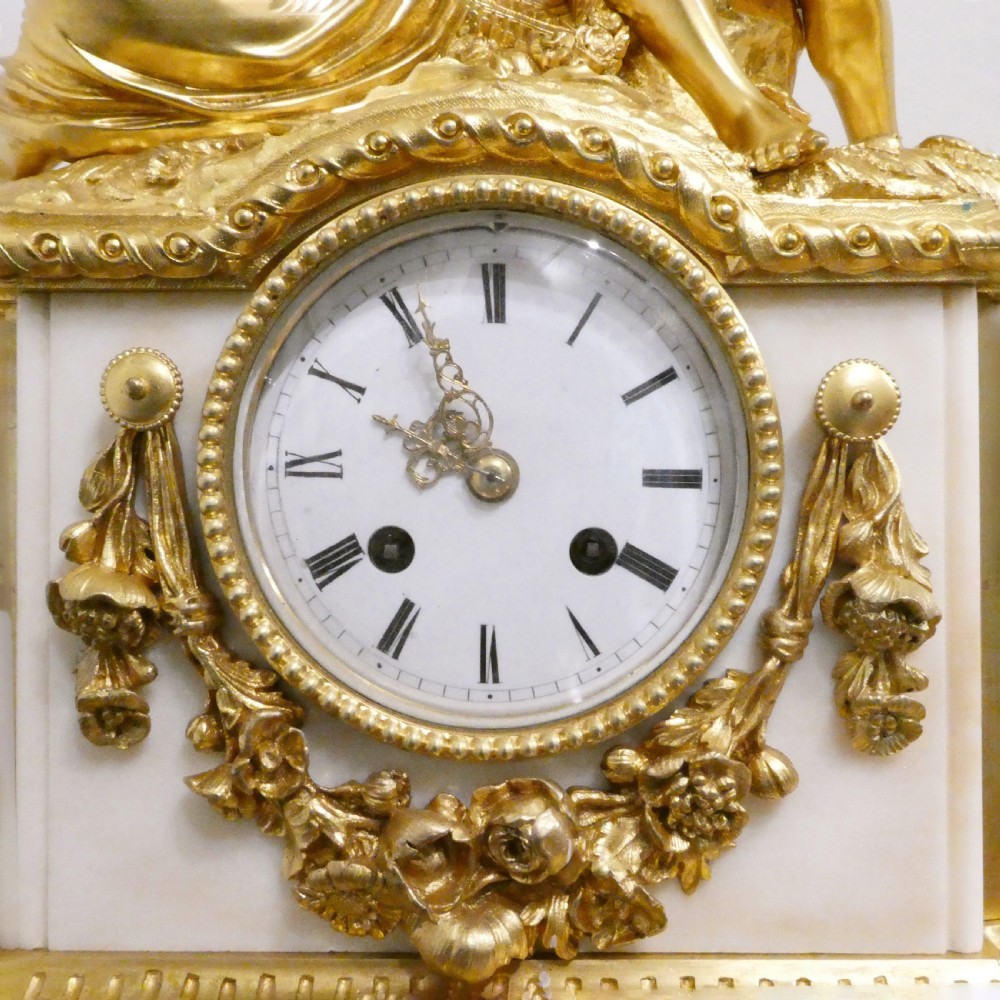 A French gilt bronze and white marble mantel clock featuring a classical figural sculpture on top and decorative floral mounts around the dial. View III