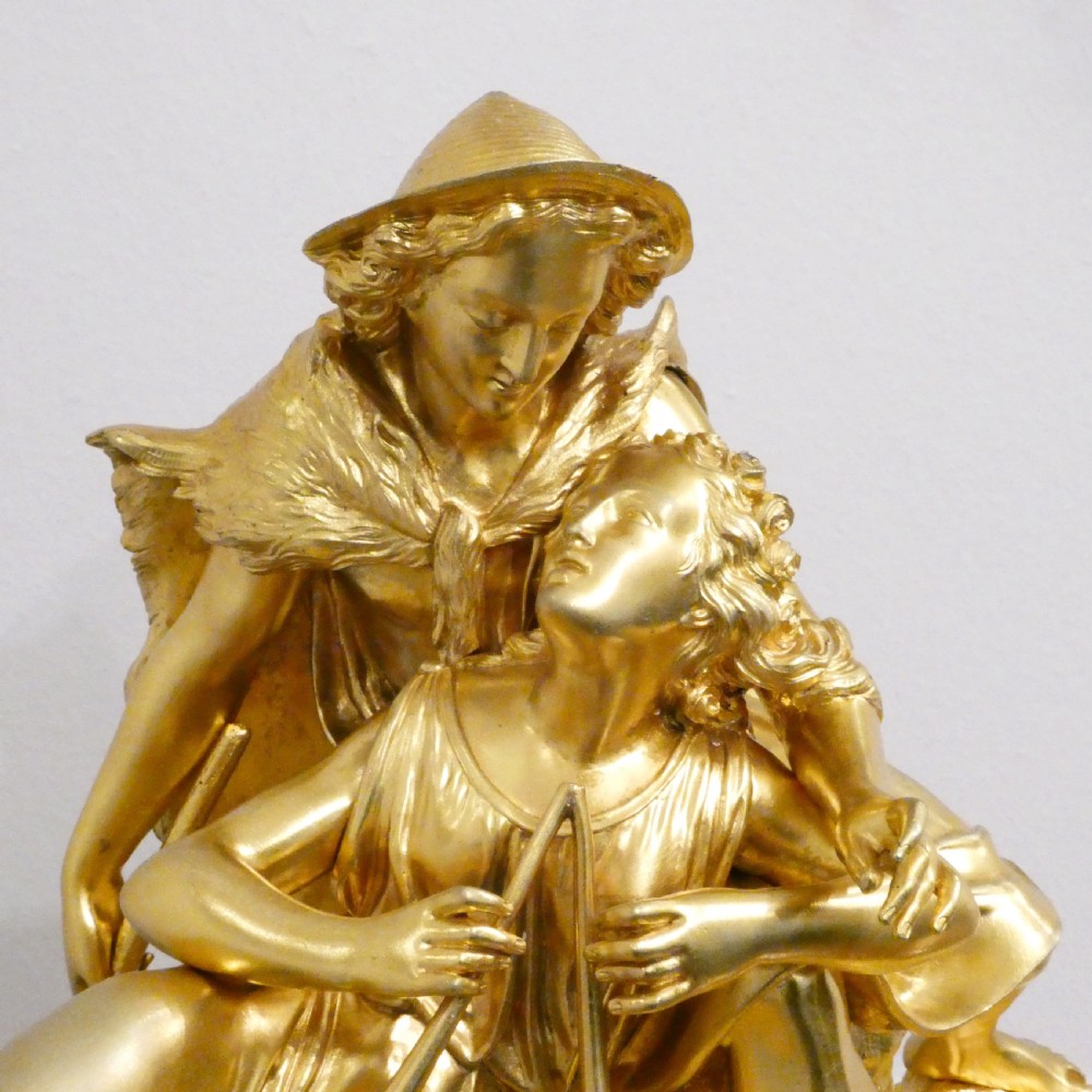 A French gilt bronze and white marble mantel clock featuring a classical figural sculpture on top and decorative floral mounts around the dial. View IV