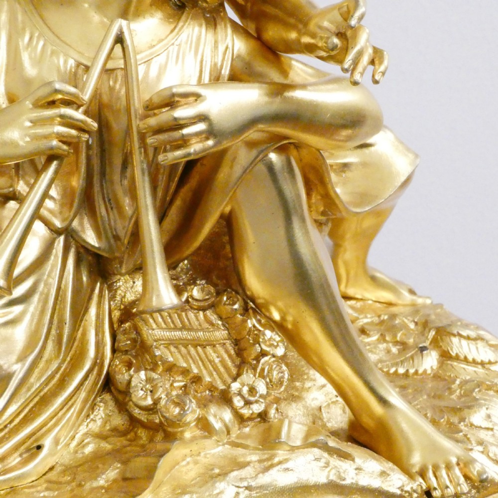 A French gilt bronze and white marble mantel clock featuring a classical figural sculpture on top and decorative floral mounts around the dial. View VII