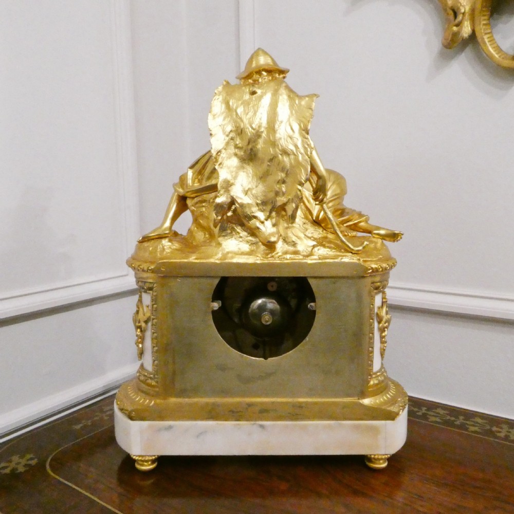 A French gilt bronze and white marble mantel clock featuring a classical figural sculpture on top and decorative floral mounts around the dial. View XIII
