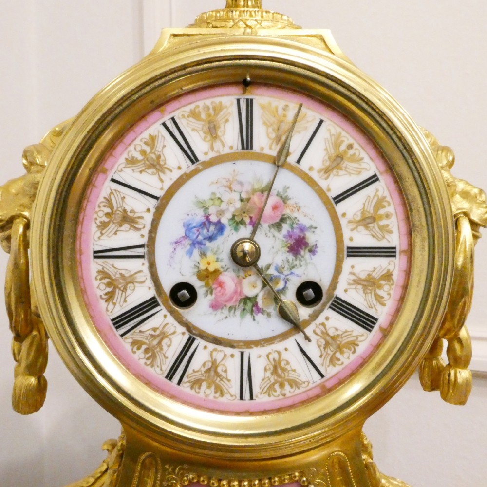 A French Louis XV style gilt bronze mantel clock featuring a hand-painted porcelain dial, lower cherub panel, scroll feet, and an ornamental urn finial. View III