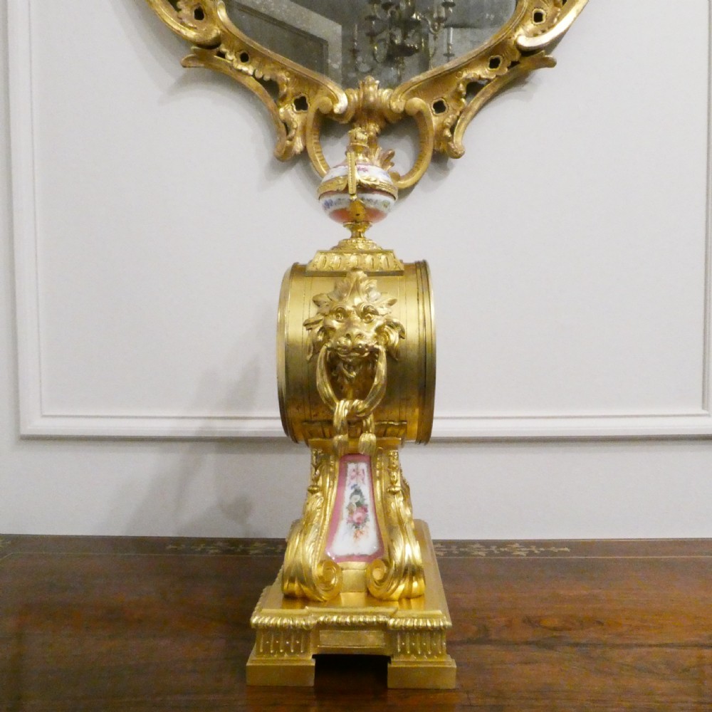A French Louis XV style gilt bronze mantel clock featuring a hand-painted porcelain dial, lower cherub panel, scroll feet, and an ornamental urn finial. View XIII
