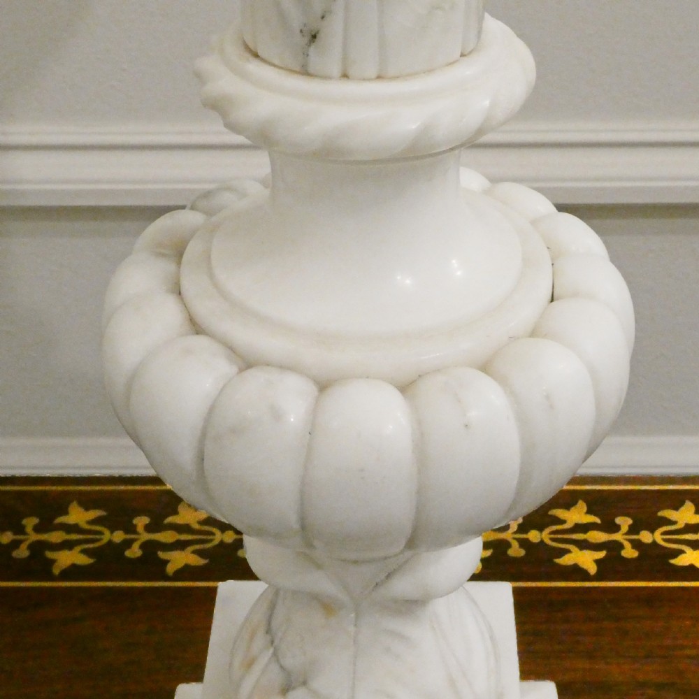 An early 20th-century carved white alabaster table lamp featuring an urn-shaped stem, square plinth base, and a pleated white fabric lampshade. View III