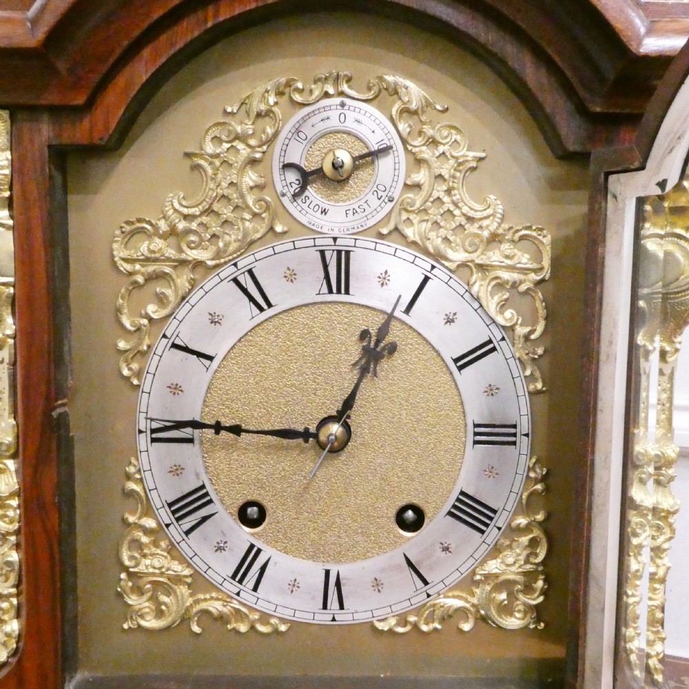 A dark mahogany arched bracket clock featuring gilt brass corner mounts, finials, and a silvered chapter ring dial with brass spandrels. View III