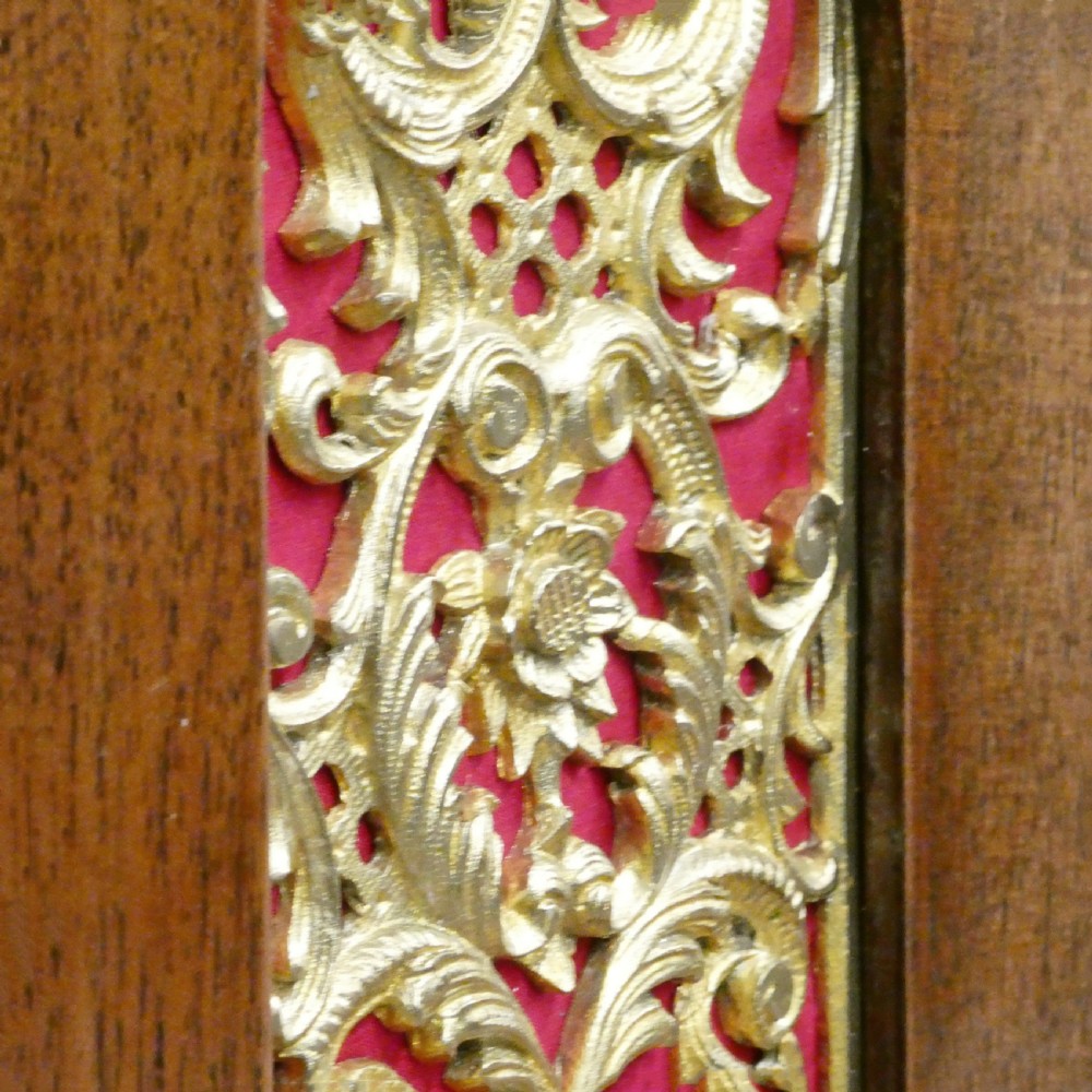 A dark mahogany arched bracket clock featuring gilt brass corner mounts, finials, and a silvered chapter ring dial with brass spandrels. View IX