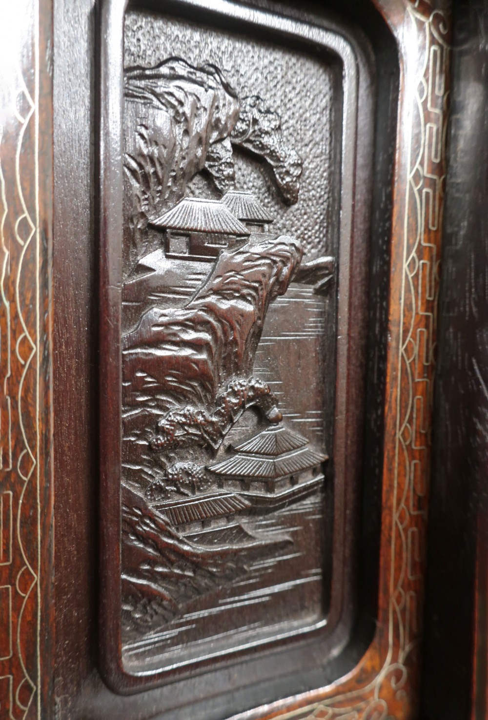 A dark carved hardwood Japanese Meiji period shodana cabinet featuring asymmetrical shelves, relief-carved panel doors, metal mounts, and a carved lower base. View IV