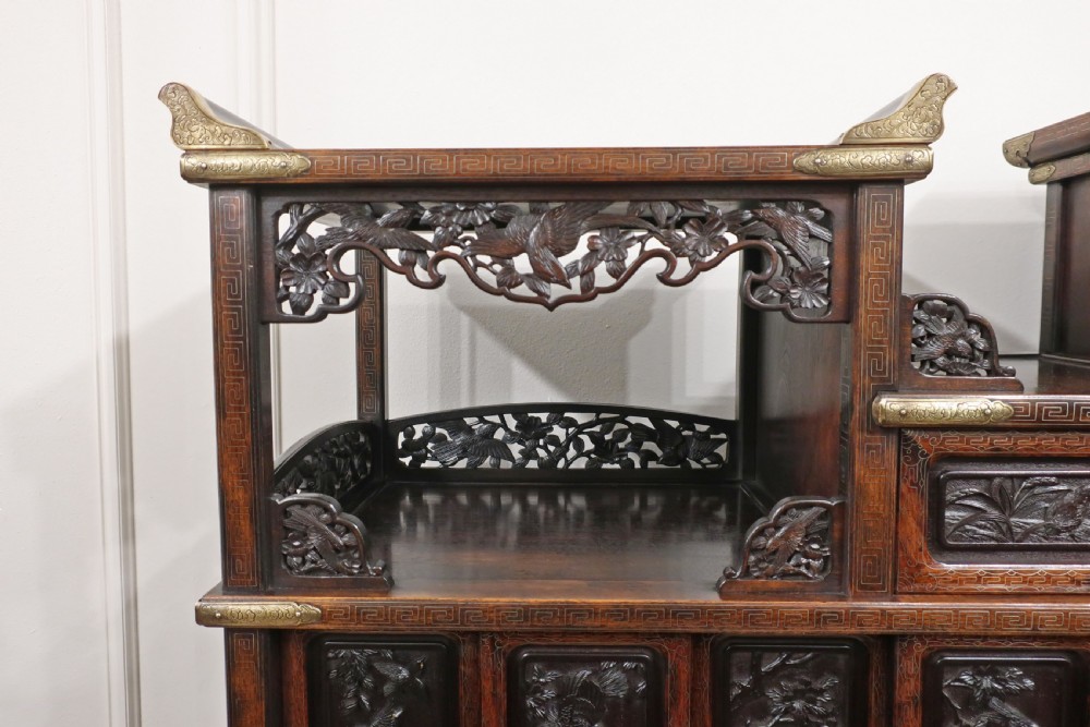A dark carved hardwood Japanese Meiji period shodana cabinet featuring asymmetrical shelves, relief-carved panel doors, metal mounts, and a carved lower base. View VII