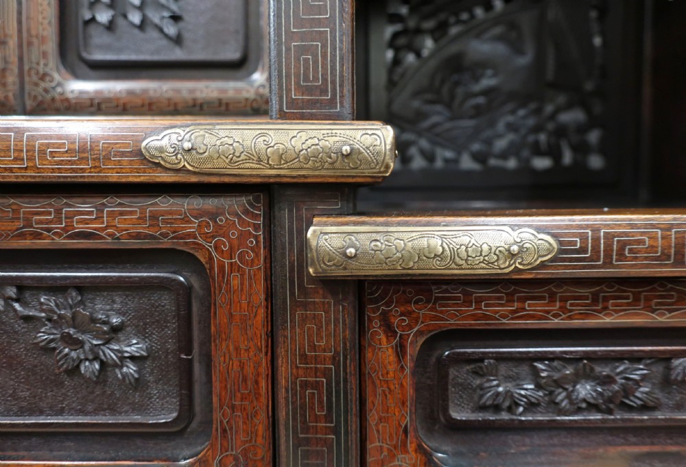 A dark carved hardwood Japanese Meiji period shodana cabinet featuring asymmetrical shelves, relief-carved panel doors, metal mounts, and a carved lower base. View XXII