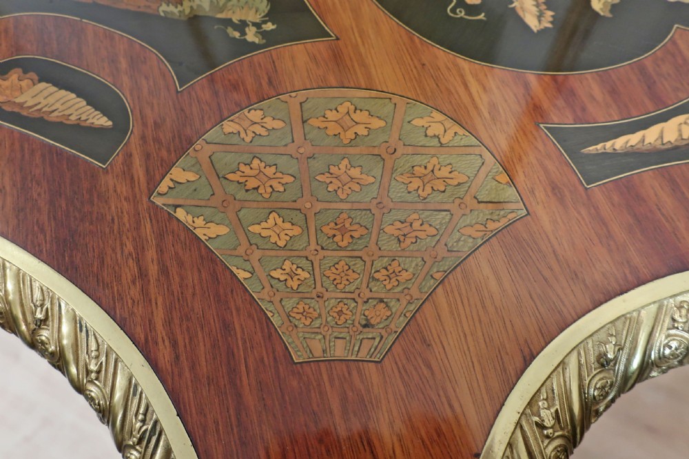 A French Louis XV style writing table featuring a serpentine top with floral marquetry inlay, cabriole legs, and gilt-bronze mounts. View VII