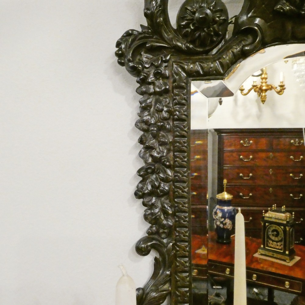 A pair of dark patinated bronze wall girandoles with ornate foliate frames surrounding central mirrored plates and three candle branches each. View VIII