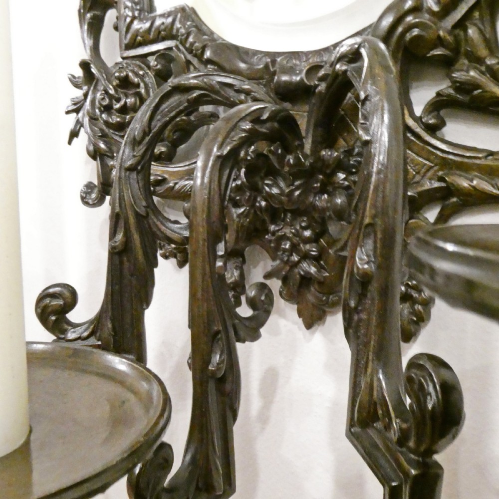A pair of dark patinated bronze wall girandoles with ornate foliate frames surrounding central mirrored plates and three candle branches each. View XIII