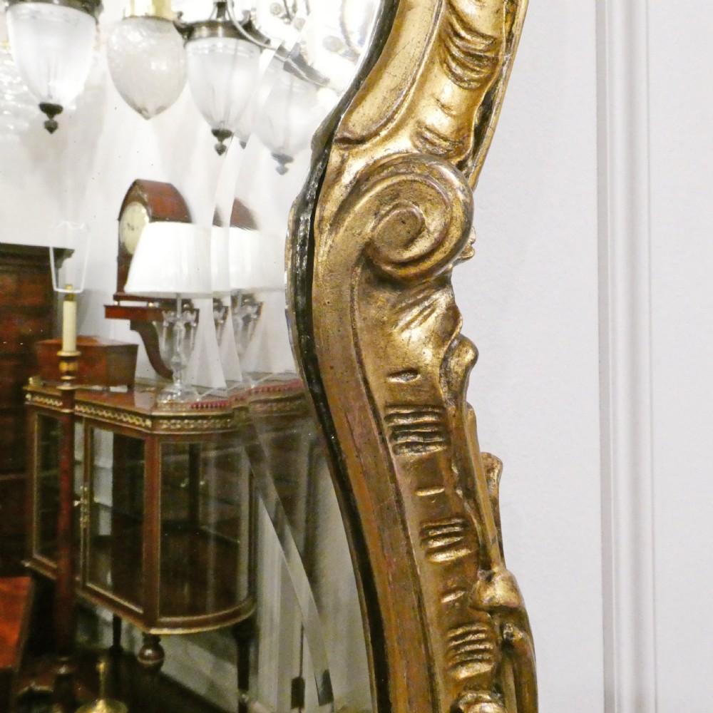 A pair of ornate French Rococo style wall mirrors featuring carved giltwood frames with scrollwork crests and lattice detailing. View VI