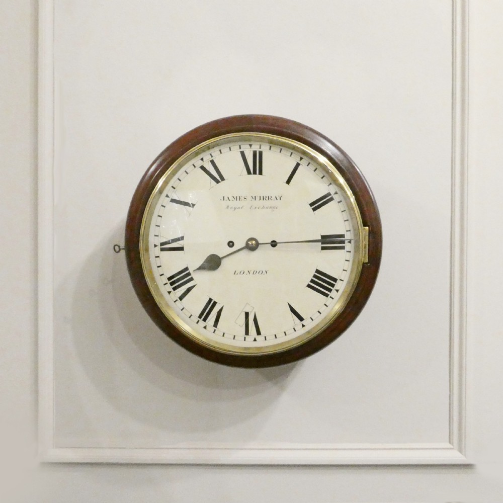 A circular Georgian wall clock featuring a mahogany surround, brass bezel, white dial with Roman numerals, and signature reading James Murray London.