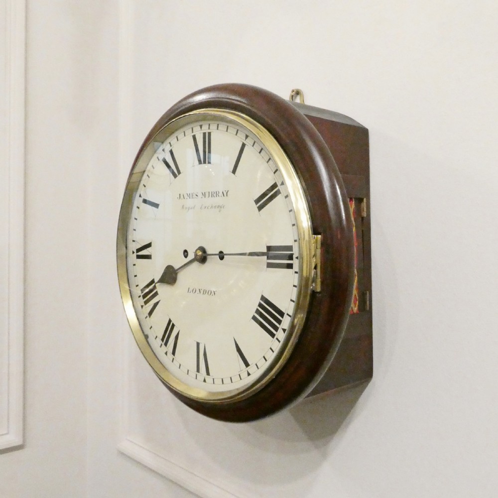 A circular Georgian wall clock featuring a mahogany surround, brass bezel, white dial with Roman numerals, and signature reading James Murray London. View II