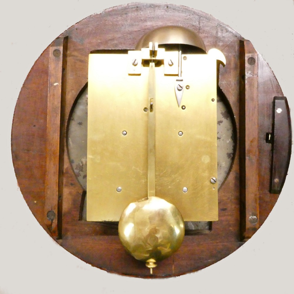 A circular Georgian wall clock featuring a mahogany surround, brass bezel, white dial with Roman numerals, and signature reading James Murray London. View VII