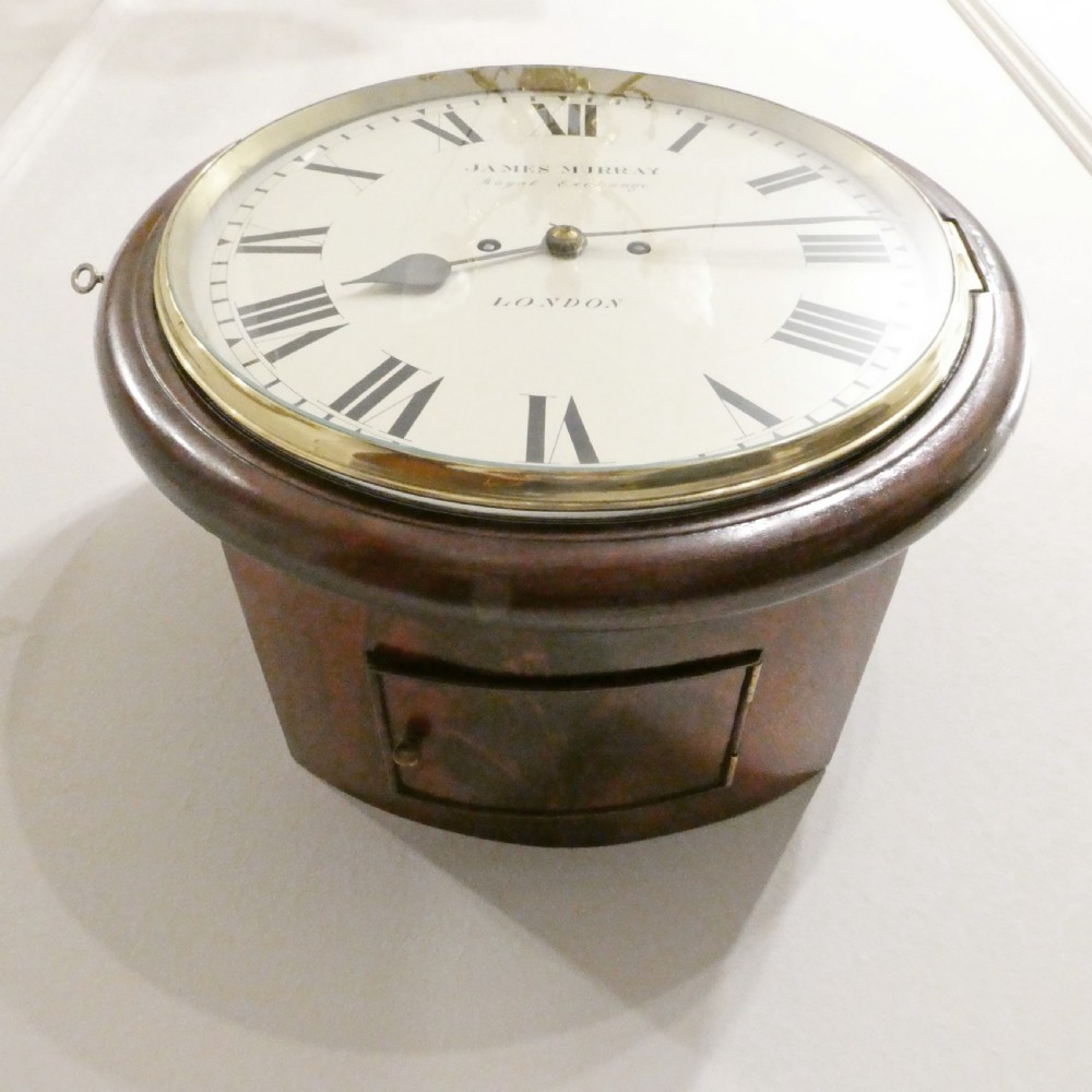 A circular Georgian wall clock featuring a mahogany surround, brass bezel, white dial with Roman numerals, and signature reading James Murray London. View X