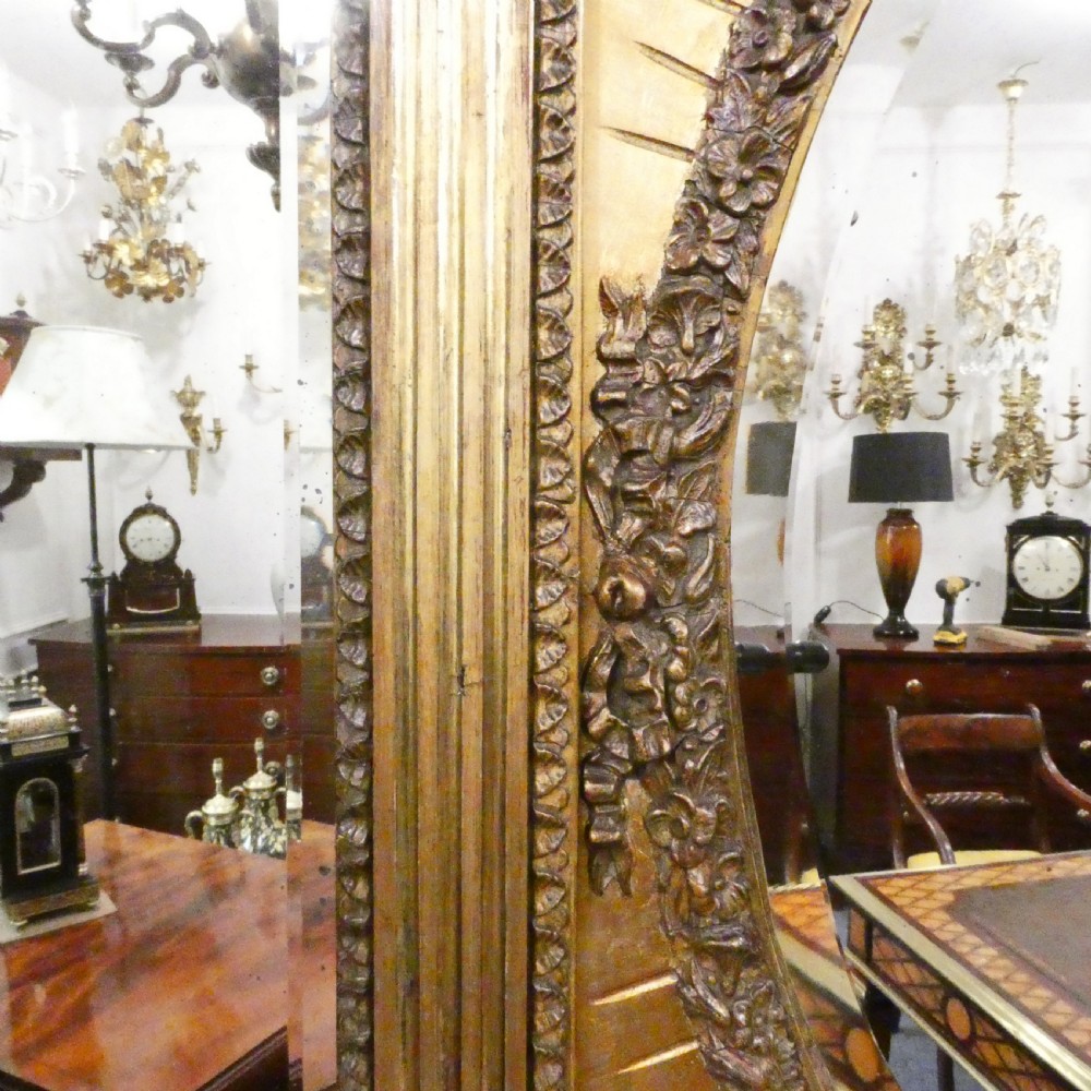 A rectangular giltwood overmantel wall mirror featuring a classical relief frieze above a central circular mirror plate flanked by two rectangular mirrored sections. View III