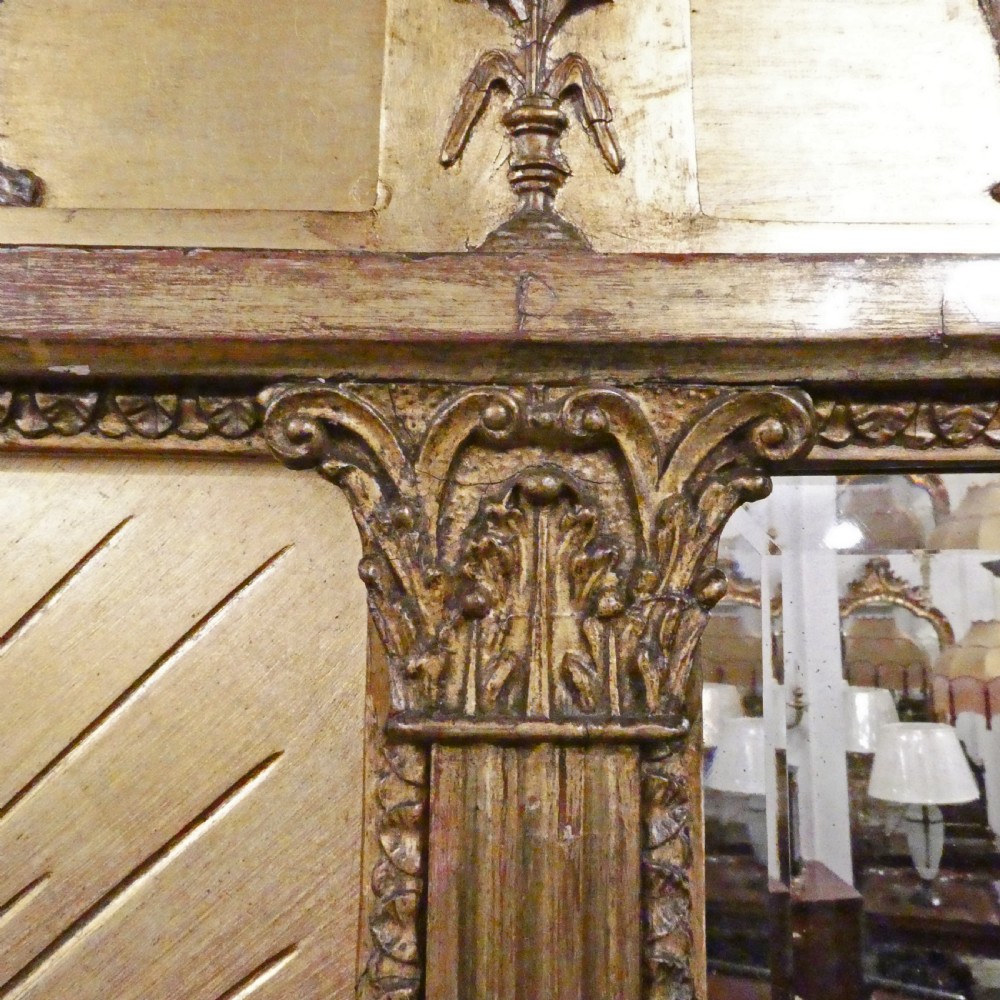 A rectangular giltwood overmantel wall mirror featuring a classical relief frieze above a central circular mirror plate flanked by two rectangular mirrored sections. View VII