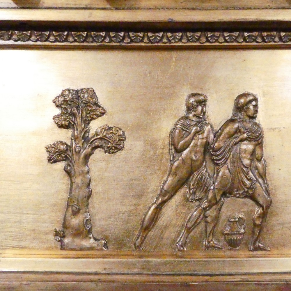 A rectangular giltwood overmantel wall mirror featuring a classical relief frieze above a central circular mirror plate flanked by two rectangular mirrored sections. View XII