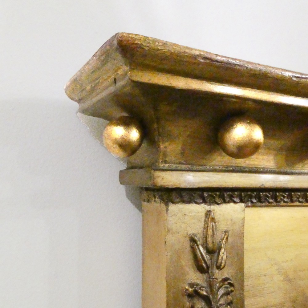 A rectangular giltwood overmantel wall mirror featuring a classical relief frieze above a central circular mirror plate flanked by two rectangular mirrored sections. View XIV