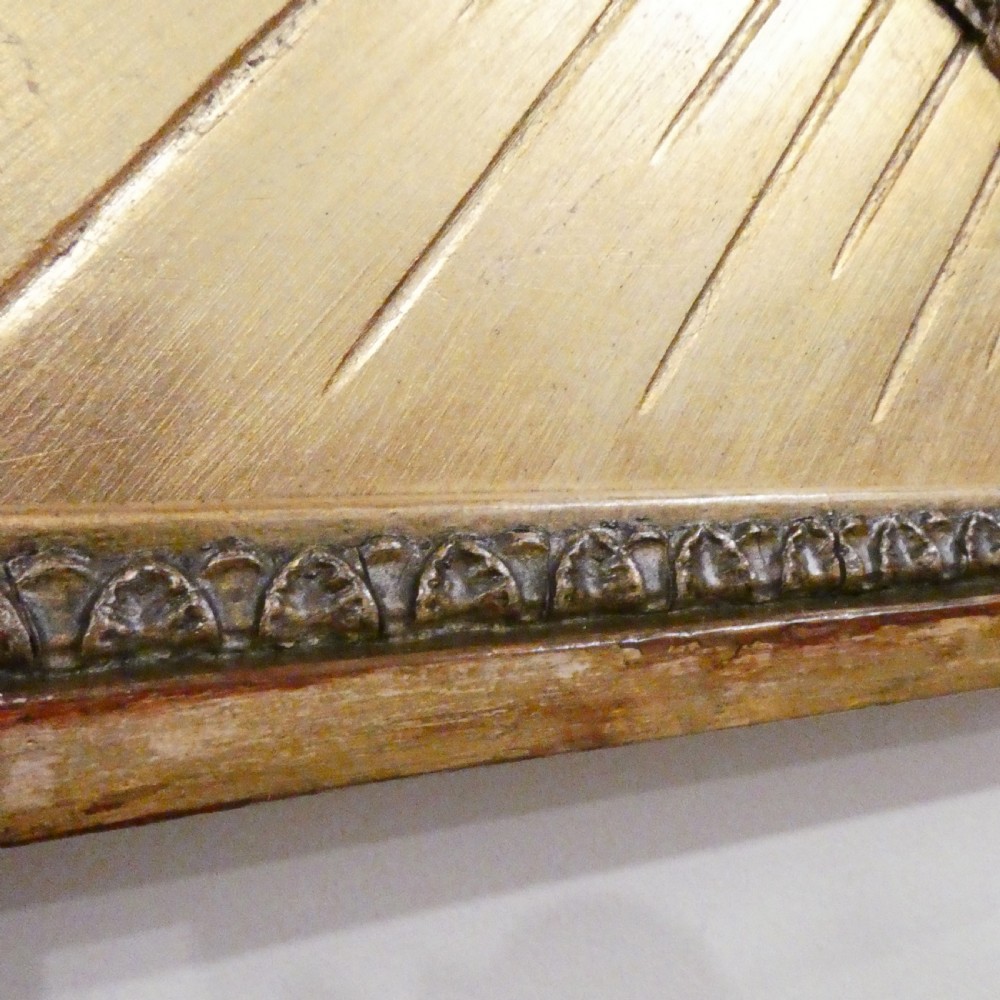 A rectangular giltwood overmantel wall mirror featuring a classical relief frieze above a central circular mirror plate flanked by two rectangular mirrored sections. View XV