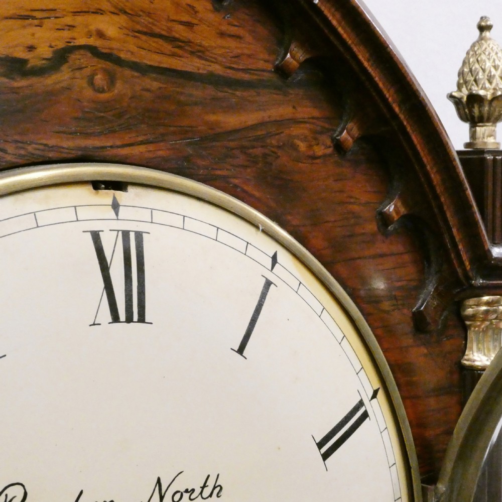 A dark rosewood William IV bracket clock featuring a gothic arch top, brass finials, brass feet, and a white dial signed Barber and North of York. View IV