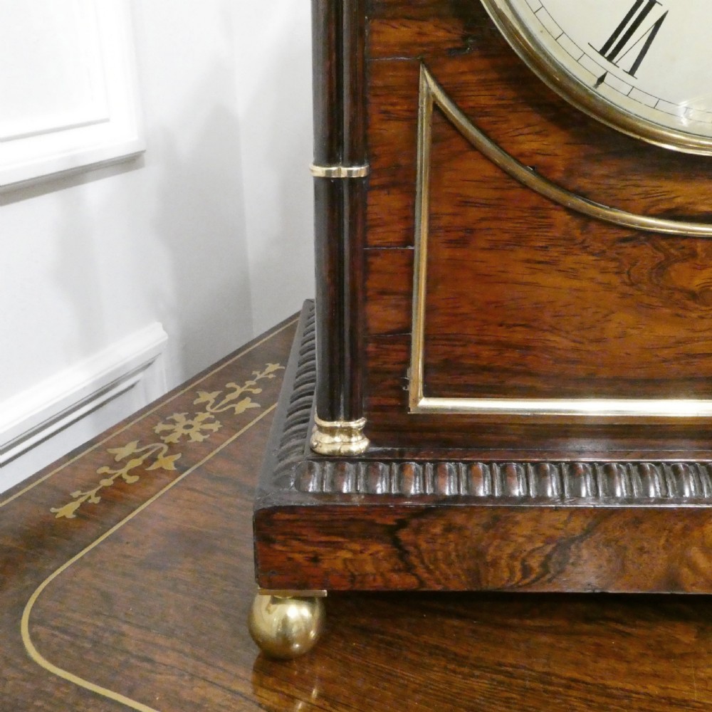A dark rosewood William IV bracket clock featuring a gothic arch top, brass finials, brass feet, and a white dial signed Barber and North of York. View V