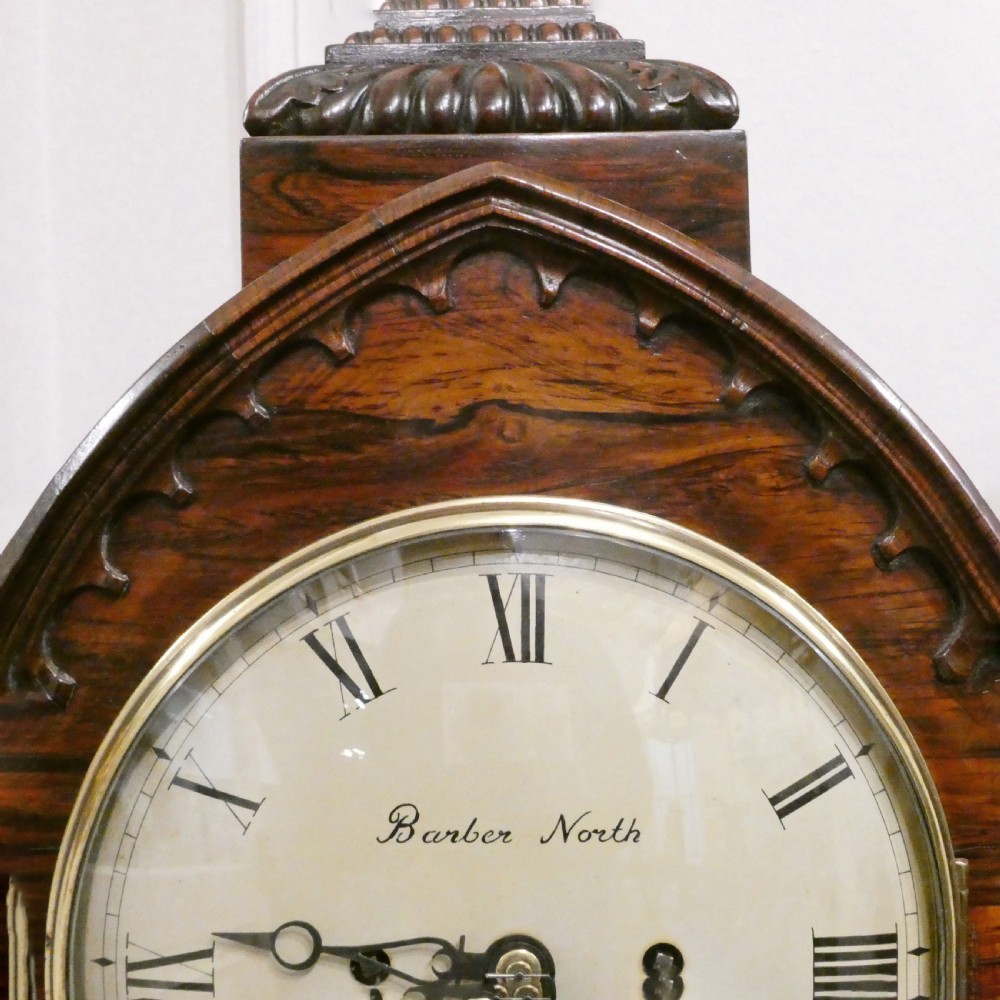 A dark rosewood William IV bracket clock featuring a gothic arch top, brass finials, brass feet, and a white dial signed Barber and North of York. View VII