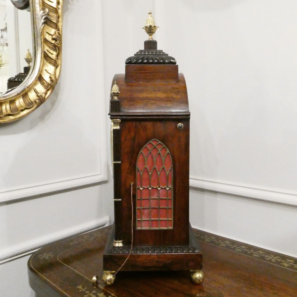 A dark rosewood William IV bracket clock featuring a gothic arch top, brass finials, brass feet, and a white dial signed Barber and North of York. View XIII