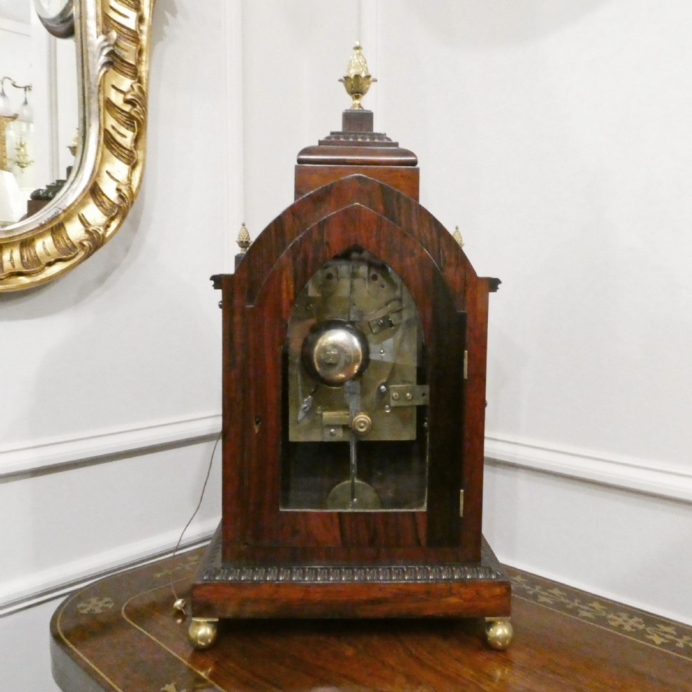 A dark rosewood William IV bracket clock featuring a gothic arch top, brass finials, brass feet, and a white dial signed Barber and North of York. View XIV