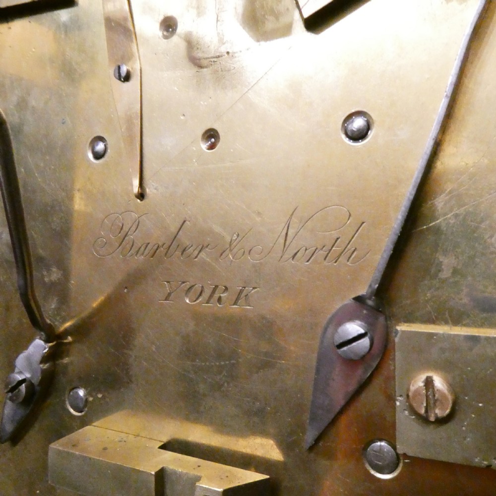 A dark rosewood William IV bracket clock featuring a gothic arch top, brass finials, brass feet, and a white dial signed Barber and North of York. View XVI