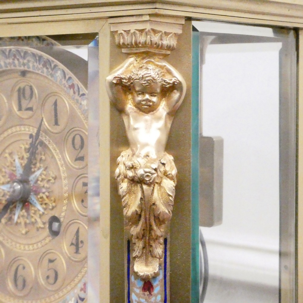 A late nineteenth-century French four-glass mantel clock featuring a green onyx base and top, champleve enamel borders, and a visible mercury pendulum. View VII