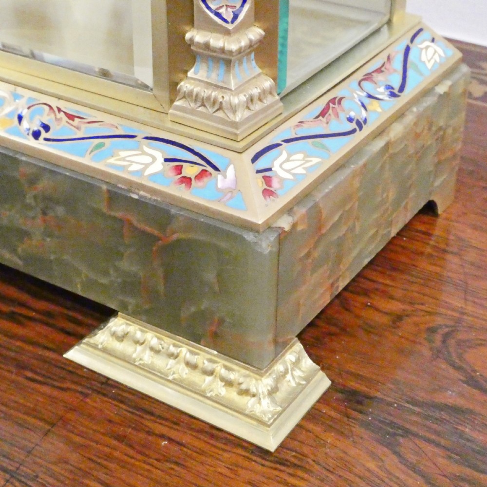 A late nineteenth-century French four-glass mantel clock featuring a green onyx base and top, champleve enamel borders, and a visible mercury pendulum. View VIII