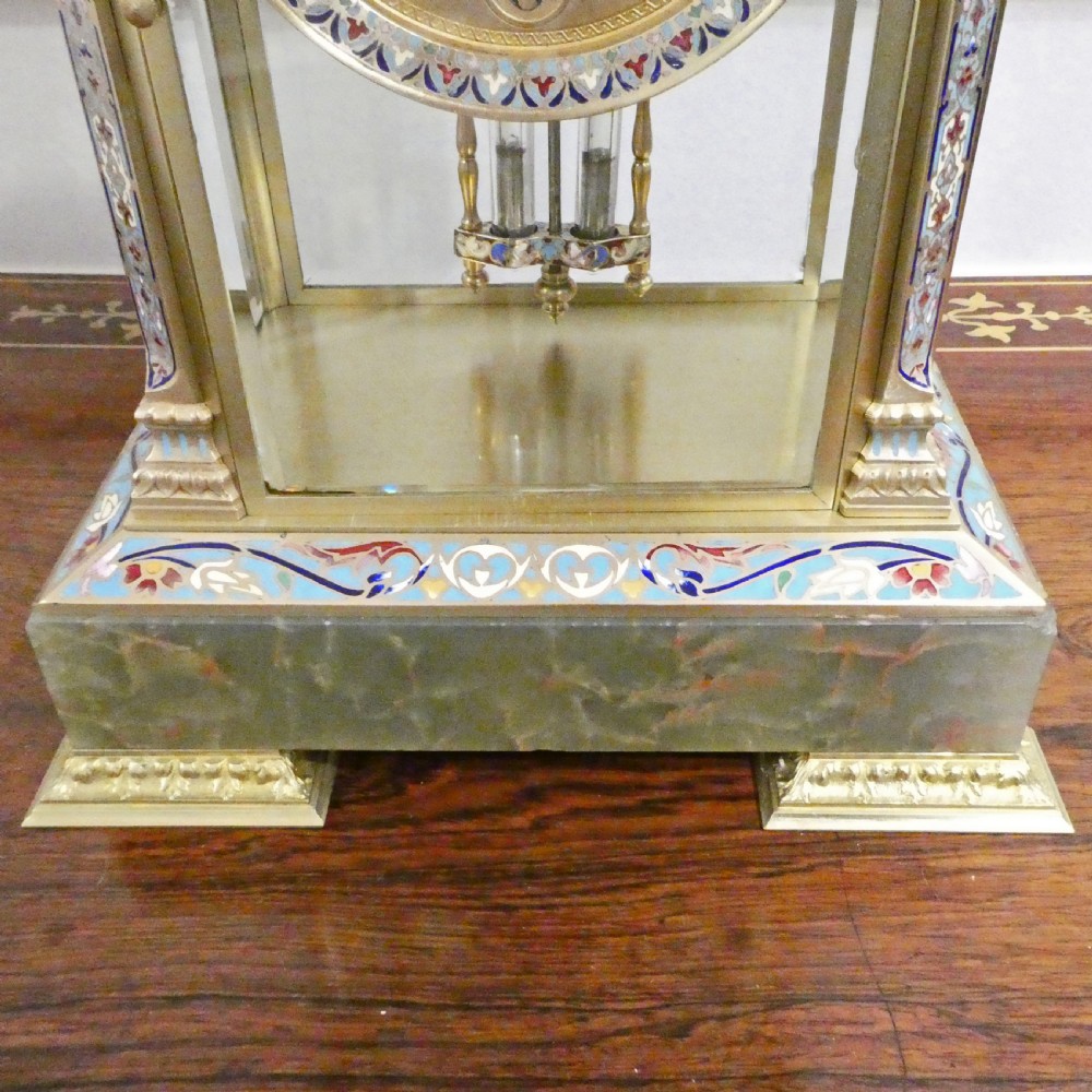 A late nineteenth-century French four-glass mantel clock featuring a green onyx base and top, champleve enamel borders, and a visible mercury pendulum. View IX
