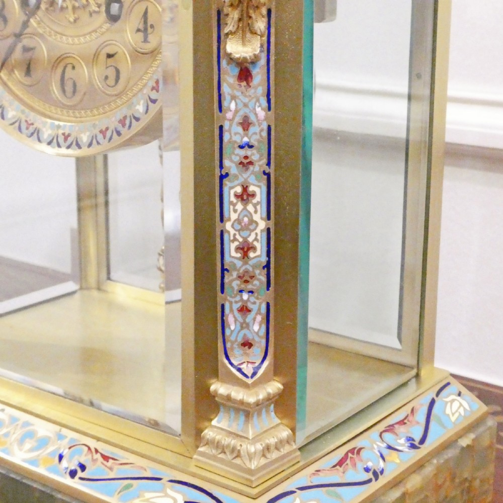 A late nineteenth-century French four-glass mantel clock featuring a green onyx base and top, champleve enamel borders, and a visible mercury pendulum. View X