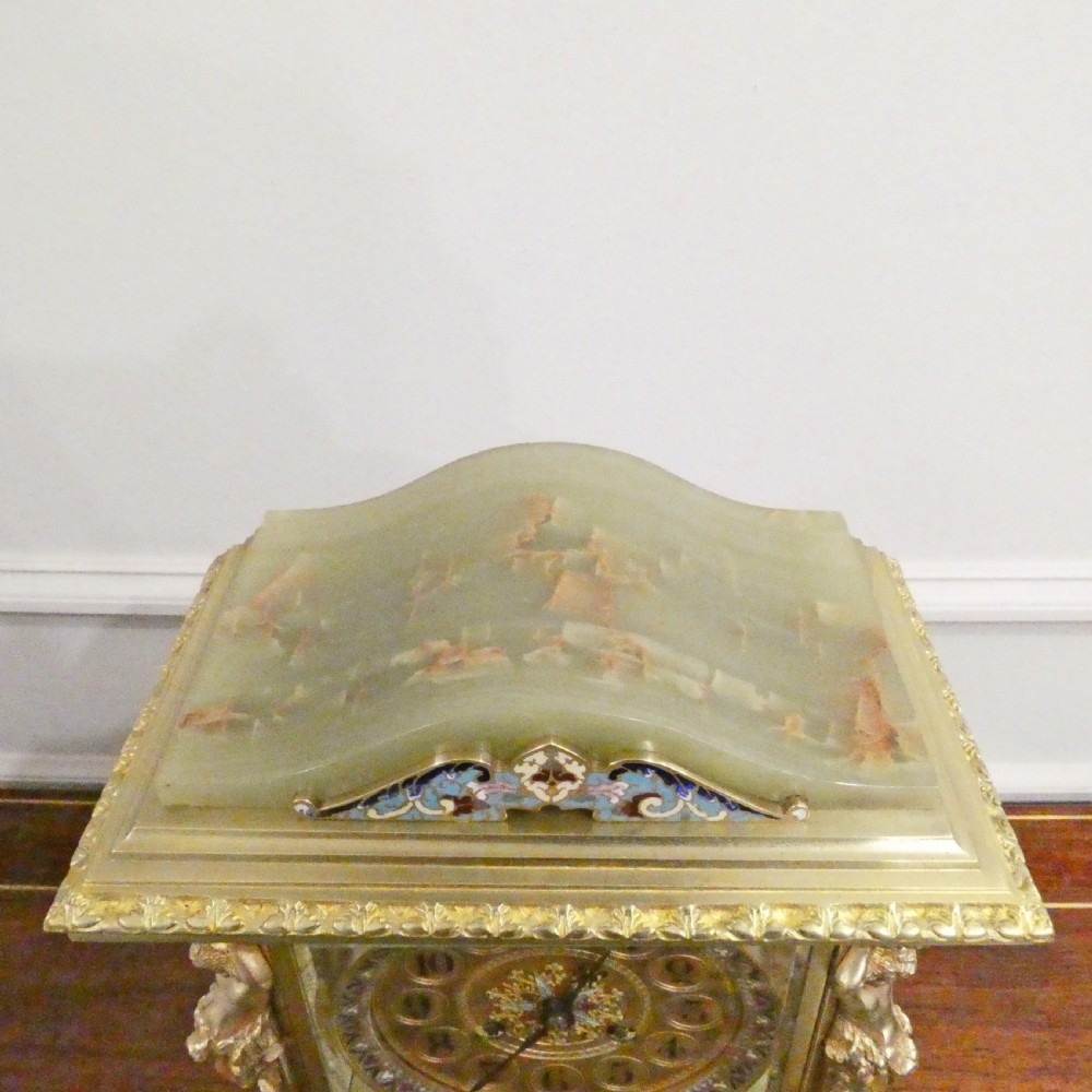 A late nineteenth-century French four-glass mantel clock featuring a green onyx base and top, champleve enamel borders, and a visible mercury pendulum. View XI